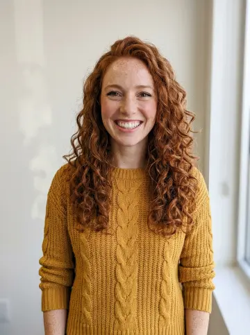 Photo of a red-haired woman in a mustard sweater cast on keys